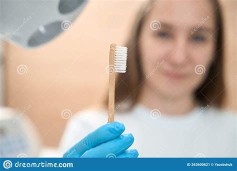 Woman Dentist In Dental Office Holds Toothbrush In Her Hands Stock