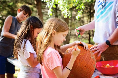Three Young Children Carving Pumpkins Outdoors Photograph By Cavan