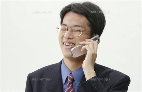 携帯電話で話しをする日本人ビジネスマン[02266003326]の写真素材・イラスト素材｜アマナイメージズ