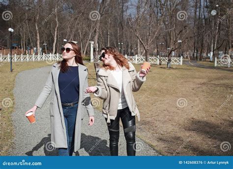Two Women Girlfriends Drink Coffee In The Park Stock Photo Image Of