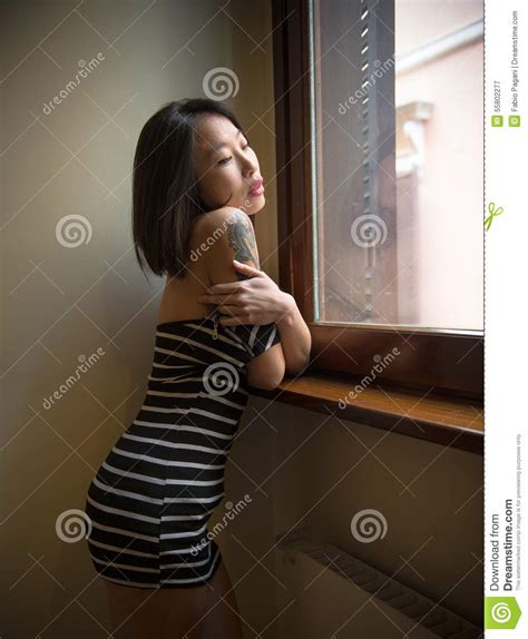 Het Mooie Sensuele Aziatische Vrouw Stellen Nadenkend Bij Venster Stock Afbeelding Image Of