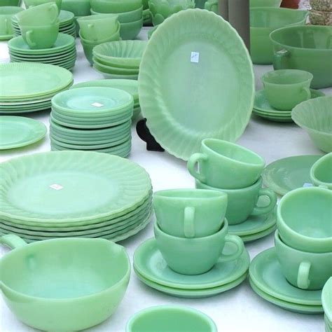 A Table Topped With Lots Of Green Cups And Saucers On Top Of White Tables