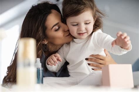 Attractive Female Playing With Her Daughter While Doing Makeup Stock