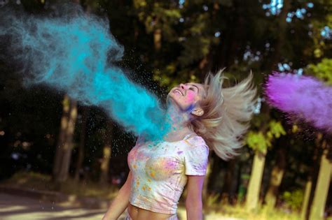 Premium Photo Expressive Blonde Woman With Hair In Motion Playing With Holi Powder Exploding