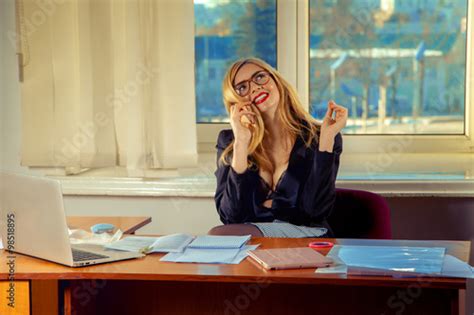 Portrait Of A Pretty Secretary Sitting At Her Desk And Smiling A Stock