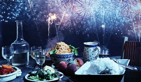 A Table Topped With Plates And Bowls Filled With Food Next To Firework