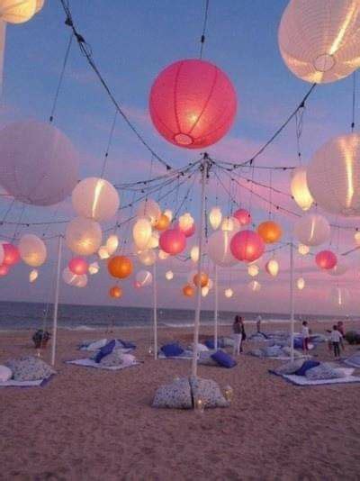 Many Paper Lanterns Are Hanging From The Ceiling On The Beach As People