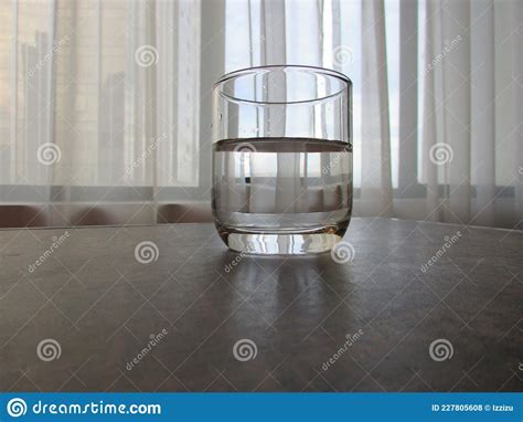 A Glass Of Crystal Clear Drinking Water On Top Of A Wooden Table Stock