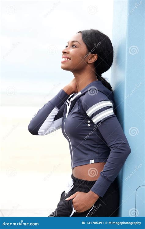 Smiling Young Black Woman Leaning Against Wall Outside Stock Image