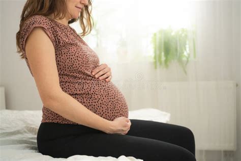 A Cute Pregnant Woman Sits In Bed The Concept Of A Happy Pregnancy Months Of Waiting For A