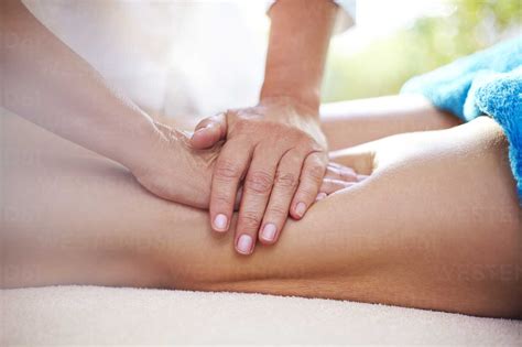 Masseuse Rubbing Womans Legs Stock Photo