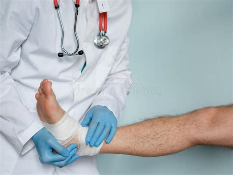 Close Up Of Doctor Bandaging One Injured Foot After An Accident Stock