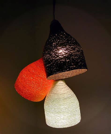The plastic bottles are kept in their original form but perforated at their ends and simply assembled with the ties. Decorative DIY Yarn Lamp Ideas