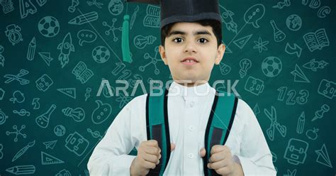 طالب مدرسي عربي خليجي سعودي يرتدي قبعة التخرج ، يرتدي حقيبة ظهر مدرسية ، انتهاء فصل دراسي