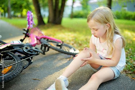 Cute Little Girl Sitting On The Ground After Falling Off Her Bike At