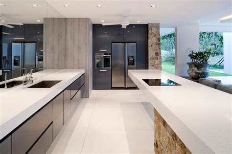 A Beautiful And Large Rectangular Kitchen With A Mirrored Wall To The