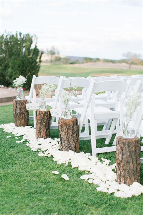 Wooden Logs Stumps Along Ceremony Aisle White Garden Chairs