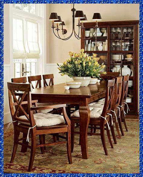 A Dining Room Table With Chairs And A Vase Filled With Flowers On Top Of It