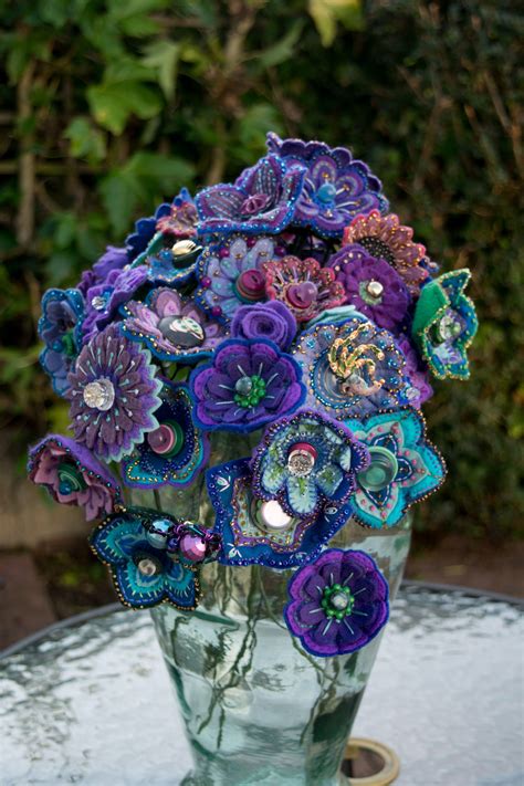 Maybe you would like to learn more about one of these? Flowers, felt, embroidered with beads and vintage buttons ...