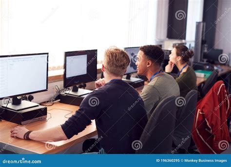 Group Of College Students Studying Computer Design Sitting At Line Of