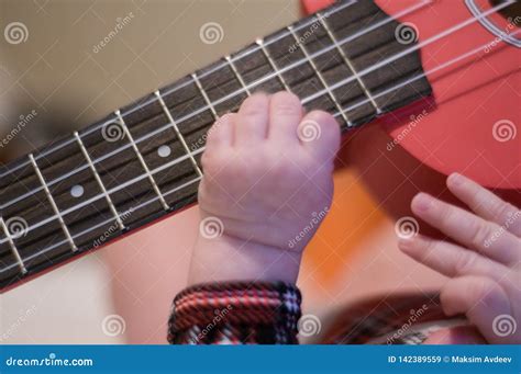 Baby Fingers Plays Guitar Ukulele Strings And Frets Stock Image