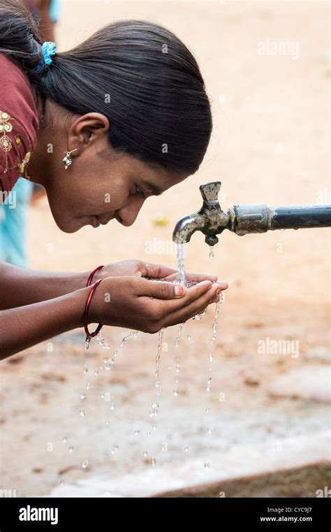 Indian Girl Drinking From A Communal Water Tap In Rural Indian Stock
