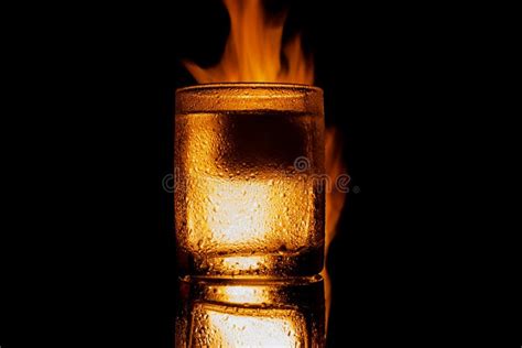 Burning Glass Of Alcohol With Ice On A Black Background Stock Image