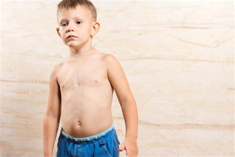 Petit enfant sérieux seins nus sur pantalons courts bleus image libre de droit par Vaicheslav
