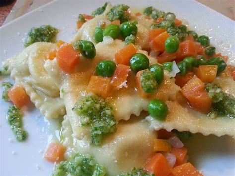 Un raviolo con ripieno di patate e menta. Ravioli alle patate con sugo dell'orto e pesto di ...
