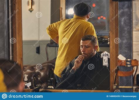 barber making haircut of attractive bearded man in barbershop stock image image of care hair