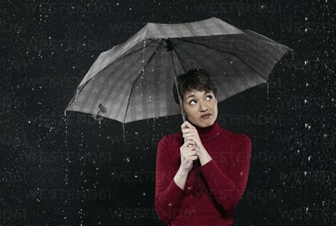 Woman Standing In Rain Holding Umbrella Stock Photo
