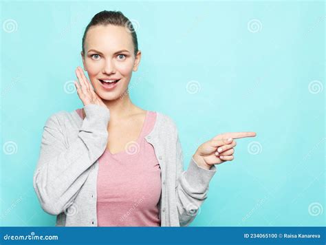 Young Woman Pointing With Finger At Blank Copy Space Aside Happy