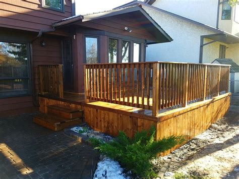 Wood railing designs for decks can use a continuous 2×6 to cap the posts. Simple deck design with wood 2x2 railing and skirting ...