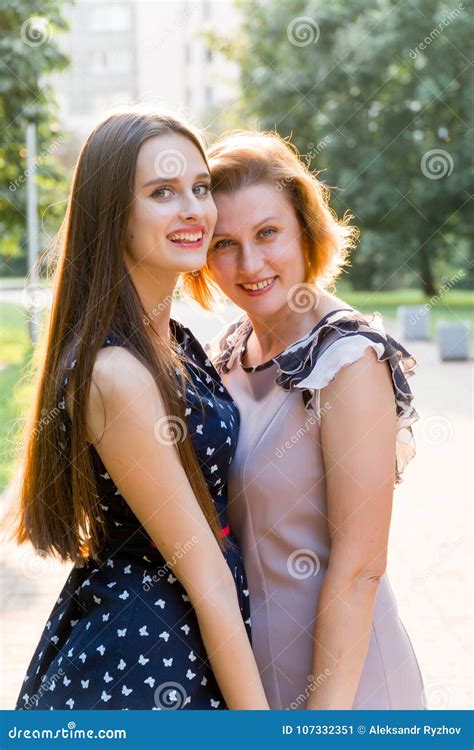 Closeup Portrait Of Adult Daughter And Mother Outdoors Pretty Brunette