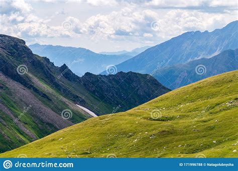 Panorama Of Picturesque Blue Mountainsides And Green Alpine Meadows