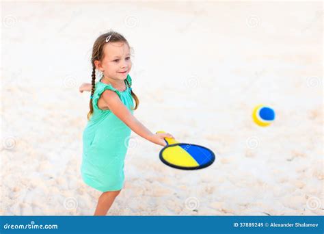 Маленькая девочка играя теннис пляжа Стоковое Изображение изображение насчитывающей активизма