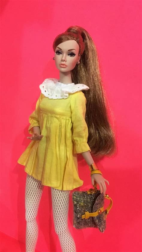 a doll with long brown hair and white stockings holding a purse in her right hand