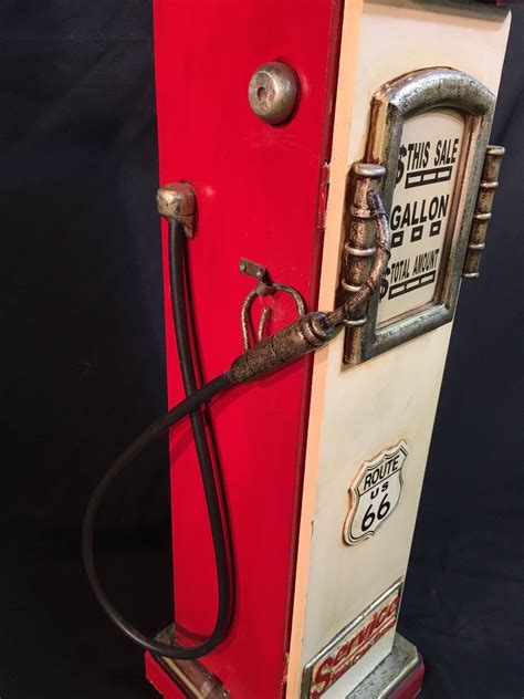 The front is a door with 4 compartments behind it for placing cd's in. VINTAGE ROUTE 66 GAS PUMP SHAPED WOODEN CABINET, 35'' TALL