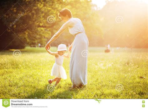Attractive Mother Dancing With Her Daughter On The Lawn Stock Image