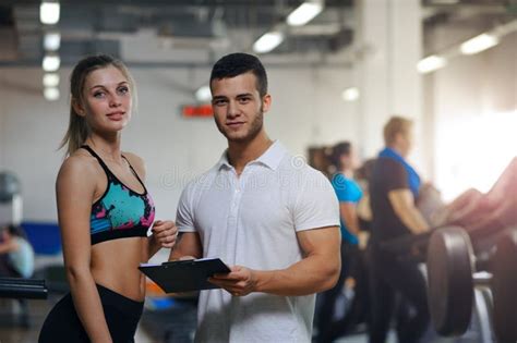 Happy Young Woman And Her Personal Trainer In Gym Stock Image Image