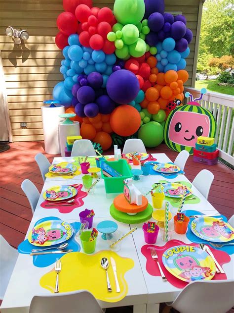 The Table Is Set With Colorful Balloons And Plates