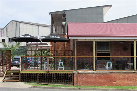 The Outside Of A Restaurant With Tables And Umbrellas