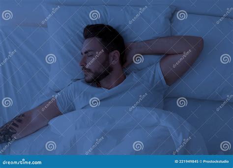 Young Man Sleeping Peacefully At Night Lying With Closed Eyes In