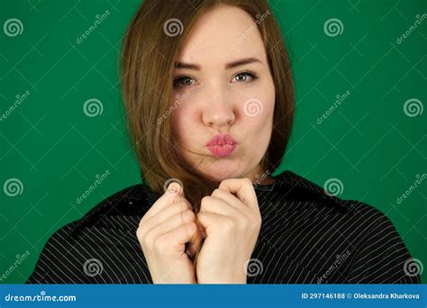 beautiful girl blow kisses woman on a green background chromakey in a black striped mens shirt
