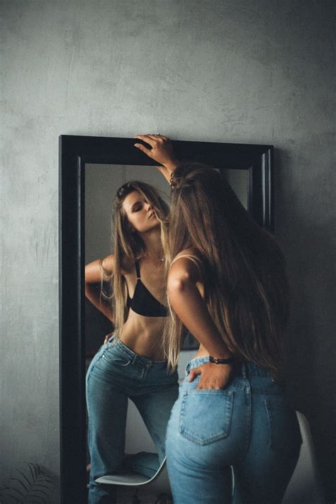 Two Women Are Standing In Front Of A Mirror
