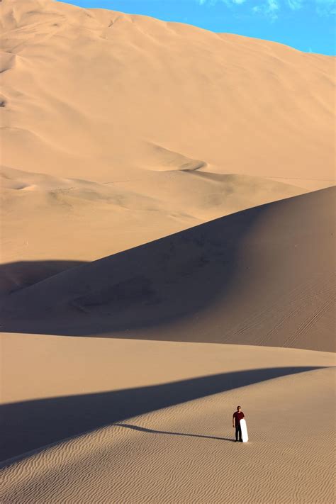 Person Walking On Desert During Daytime Photo Free Soil Image On