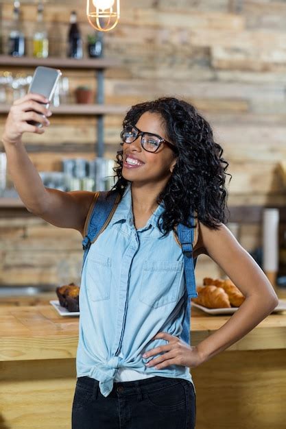 Mujer Tomando Selfie Desde Teléfono Móvil En Mostrador Foto Premium