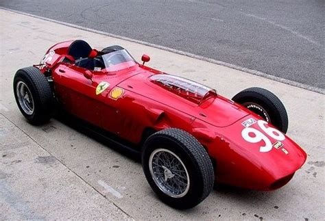 A Red Race Car Is Parked On The Side Of The Road In Front Of A Curb