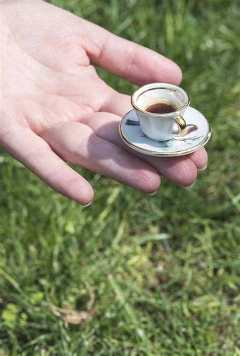 Hand hold very small cup of coffee ~ Food & Drink Photos on Creative Market