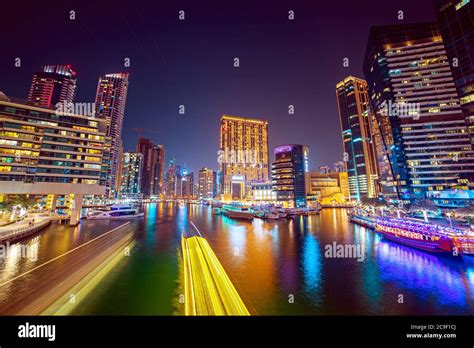 Dubai Marina At Night With Skyscrapers Boats And Reflections In The